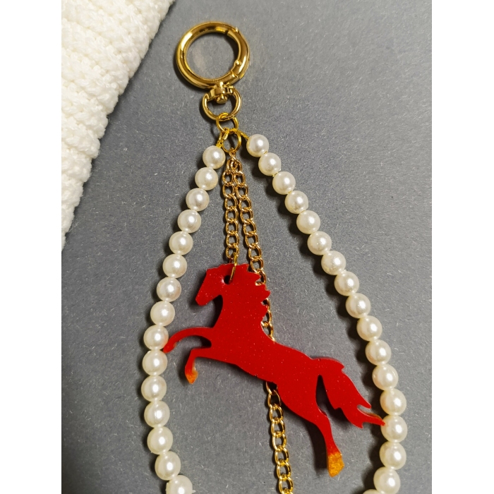 Elegancki brelok do torebki z perłami i czerwonym koniem