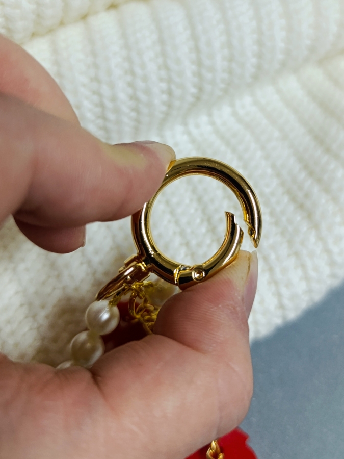 Elegancki brelok do torebki z perłami i czerwonym koniem