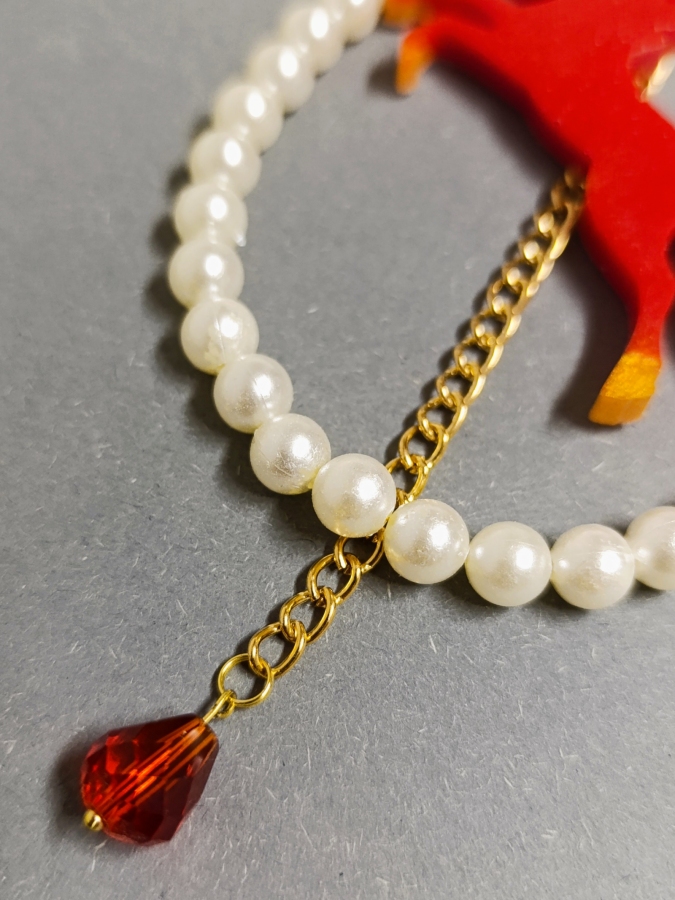 Elegancki brelok do torebki z perłami i czerwonym koniem